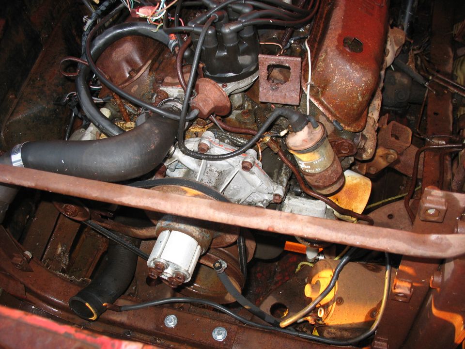 Engine bay with rusty components and visible wiring