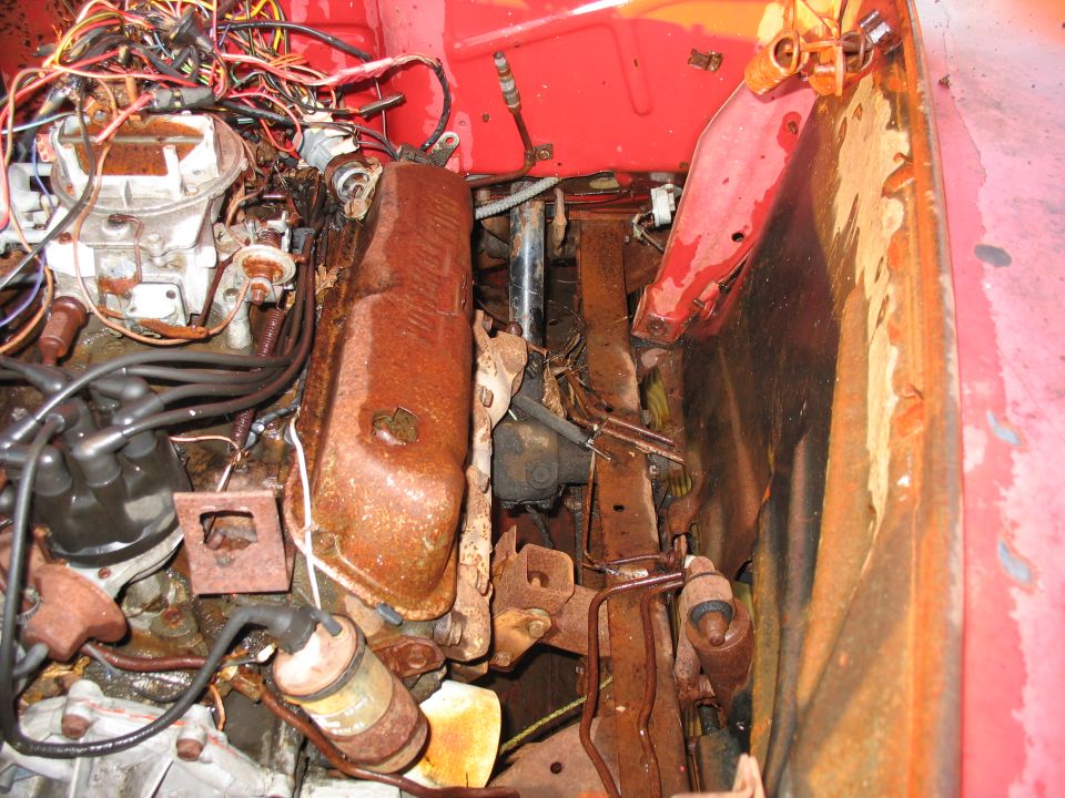 Engine bay with rusty engine parts and tangled wires