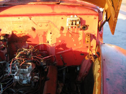 1952 Ford Pickup - The engine bay of a red truck shows a tangle of wires and exposed engine components.