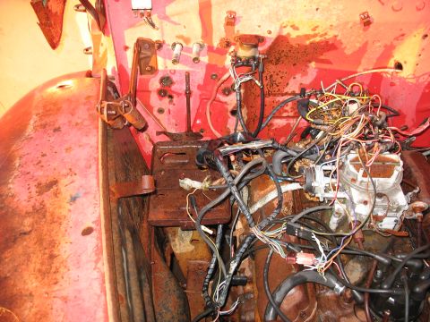 1952 Ford Pickup - The engine bay of a vehicle, showing a complex network of wires and rusty parts.