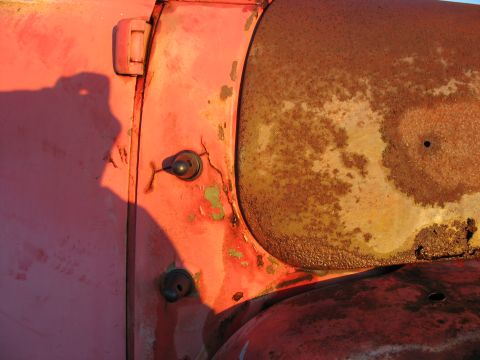 1952 Ford Pickup - Close-up of a weathered truck door and fender, showing peeling paint and significant rust.