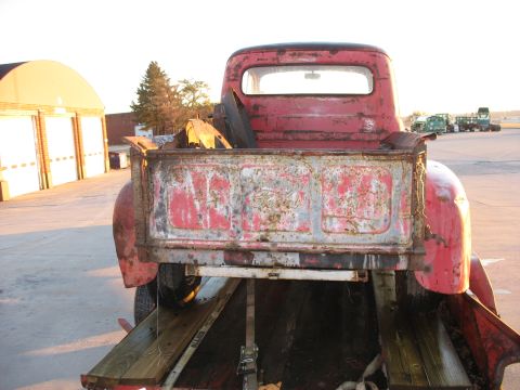 1952 Ford Pickup - This 1952 Ford Pickup truck is seen from the rear, showing its weathered tailgate and red paint.