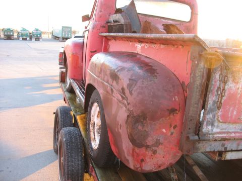 1952 Ford Pickup - Rear view of a weathered 1952 Ford Pickup truck being transported on a trailer.