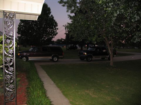 1995 Ford C-350 (Centurion Conversions) - Two Ford Broncos are visible in a residential driveway as twilight approaches.