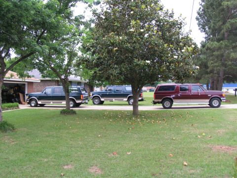 1995 Ford C-350 (Centurion Conversions) - Three Ford C-350 Centurion Conversions SUVs are parked in a residential driveway.