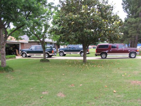 1995 Ford C-350 (Centurion Conversions) - Three Ford C-350 Centurion Conversions SUVs are parked in a residential driveway.