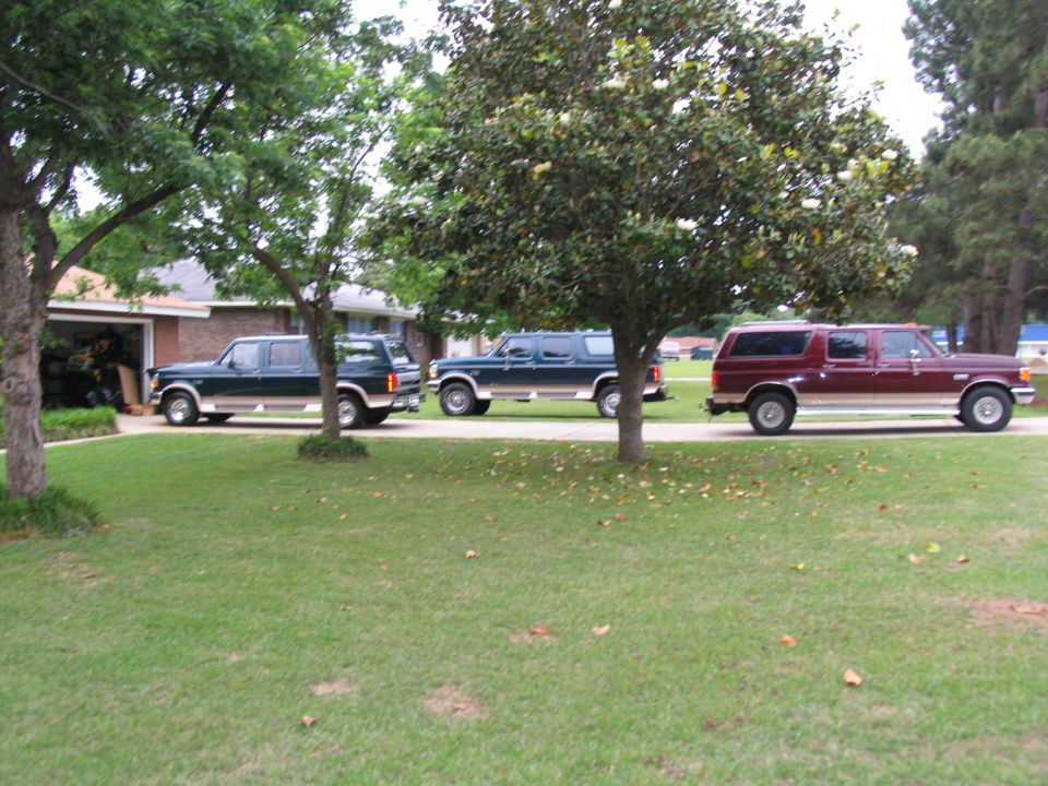 Three 1995 Ford C-350 Centurion Conversions SUVs parked side-by-side in a grassy driveway