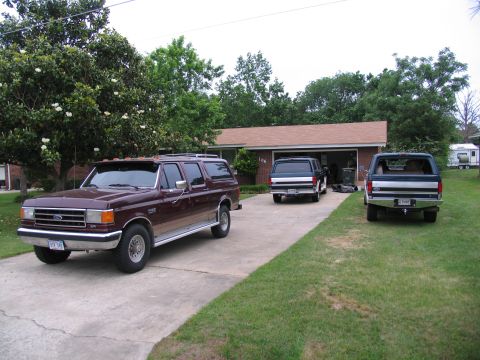 1995 Ford C-350 (Centurion Conversions) - Three Ford Bronco Centurion SUVs are parked in front of a house.