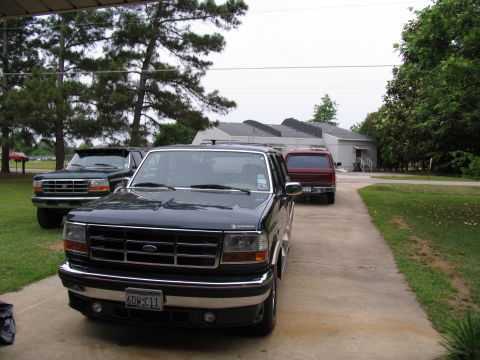 1995 Ford C-350 (Centurion Conversions) - Three SUVs are parked in a driveway in front of a building.