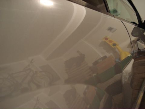 1998 Ford Taurus - Garage interior reflected on the side of a car, showing a bicycle and various items on shelves.