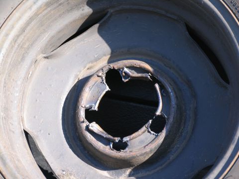 1995 Ford C-350 (Centurion Conversions) - A close-up view of a damaged wheel rim, showing cutouts around the center hub.