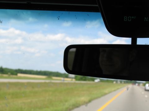 1995 Ford C-350 (Centurion Conversions) - Driving on a highway with a clear sky and green fields visible through the windshield.