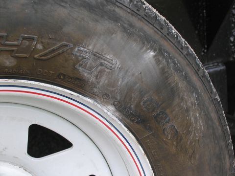 1995 Ford C-350 (Centurion Conversions) - Close-up of a tire and wheel assembly, showing branding and decorative stripes on the wheel.