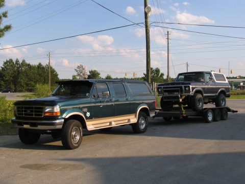 1978 Ford Bronco - A 1978 Ford Bronco is being towed by a Ford Econoline van on a sunny day.