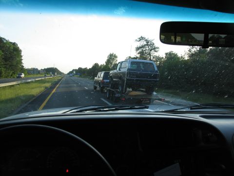 1978 Ford Bronco - A dark blue 1978 Ford Bronco is transported on a trailer down the highway.