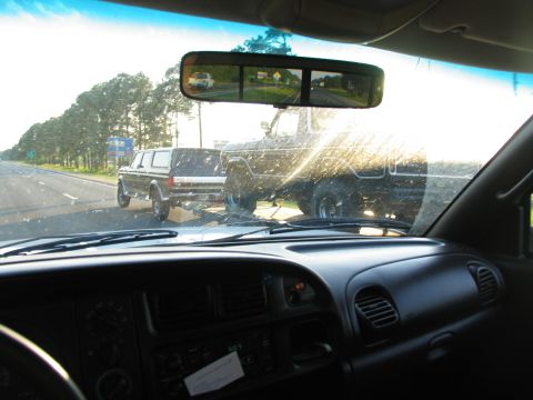 1978 Ford Bronco - A 1978 Ford Bronco is being towed on a trailer down a highway.