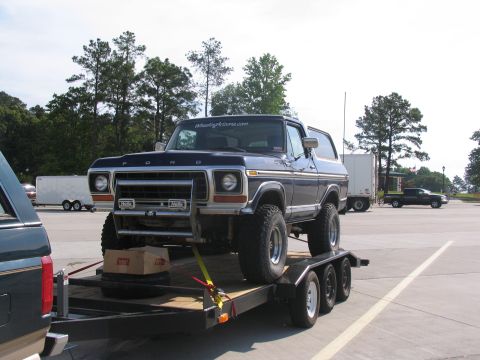1978 Ford Bronco - A dark blue Ford Bronco is secured to a trailer, ready for transport.