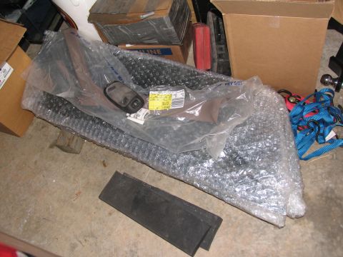 1995 Ford C-350 (Centurion Conversions) - A car part is packaged in bubble wrap, with other items and boxes in the background.
