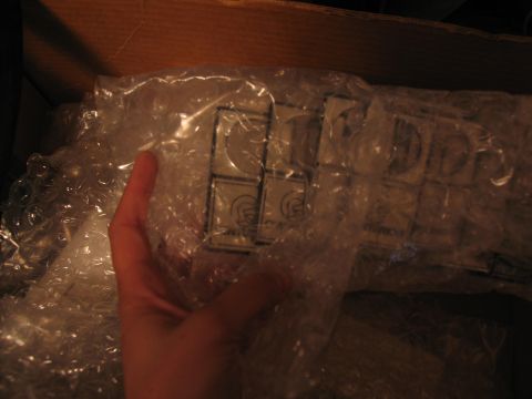 1995 Ford C-350 (Centurion Conversions) - Close-up of bubble-wrapped items with visible logos, likely car parts, inside a box.