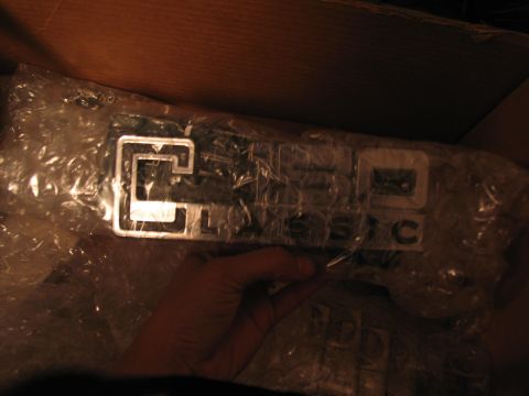 1995 Ford C-350 (Centurion Conversions) - A chrome emblem with 'C' and '350' visible, packaged in bubble wrap within a box.
