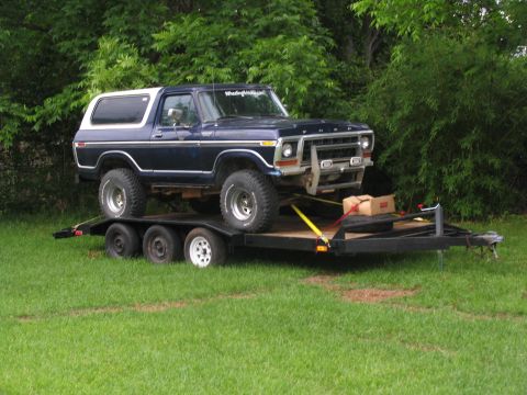 1978 Ford Bronco - A dark blue Ford Bronco is loaded onto a trailer, ready for transport.