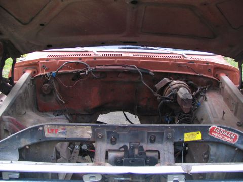 1983 Ford Bronco - The engine bay of a vehicle is shown with exposed wiring and components.