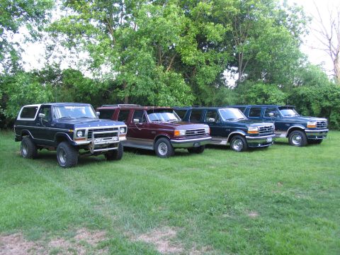 1995 Ford C-350 (Centurion Conversions) - A lineup of four Ford SUVs, including a Bronco and three extended-length models, parked on a lawn.