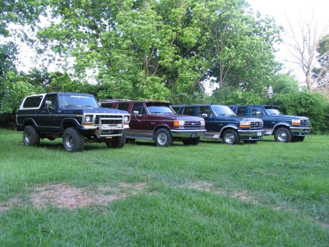 1995 Ford C-350 (Centurion Conversions) - A lineup of five Ford vehicles, including Broncos and trucks, parked on a lawn.