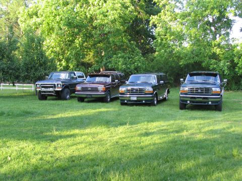 1995 Ford C-350 (Centurion Conversions) - Four Ford Centurion Conversions SUVs are parked on a lawn in front of a line of trees.
