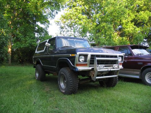 1995 Ford C-350 (Centurion Conversions) - This 1978 Ford Bronco is parked next to another Ford truck in a grassy area with trees.