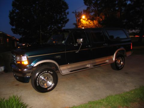 1995 Ford C-350 (Centurion Conversions) - Side view of a dark green 1995 Ford C-350 Centurion Conversion SUV.