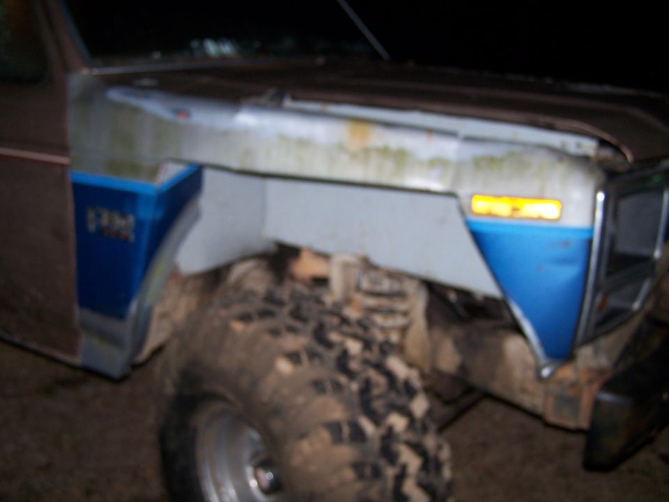 Brown and blue Ford Bronco front fender with mud-caked tire