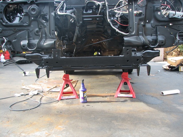 Vehicle frame on red jack stands, front view