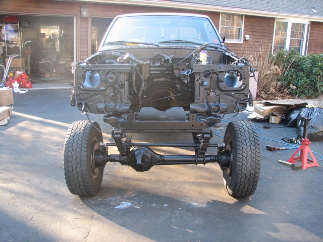Truck chassis with front wheels, suspension, and engine bay exposed