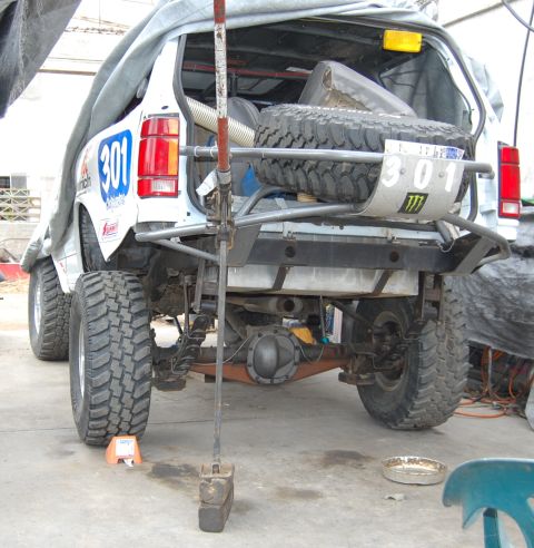 1992 Ford Explorer - This white SUV, possibly a race vehicle, is shown from the rear with a spare tire mounted externally and racing decals on its side.