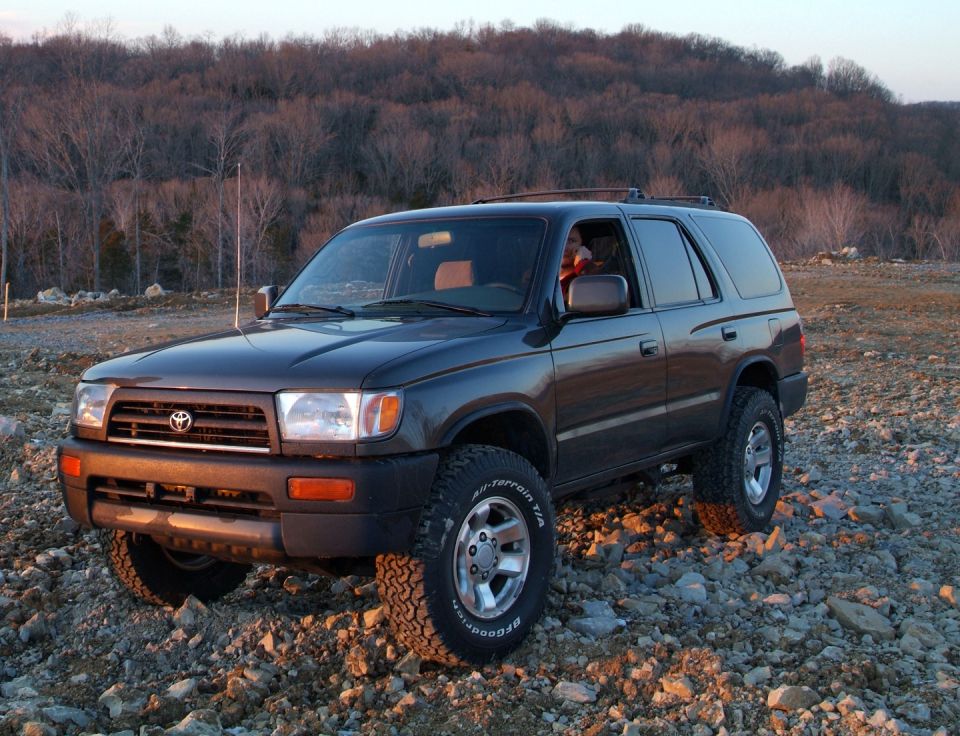 Dark gray Toyota 4Runner parked on a rocky hillside at sunset