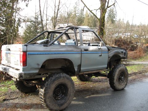 1984 Ford Bronco II - This heavily modified SUV features a custom roll cage and significant lift, suggesting it's built for off-road use. The body style points t…