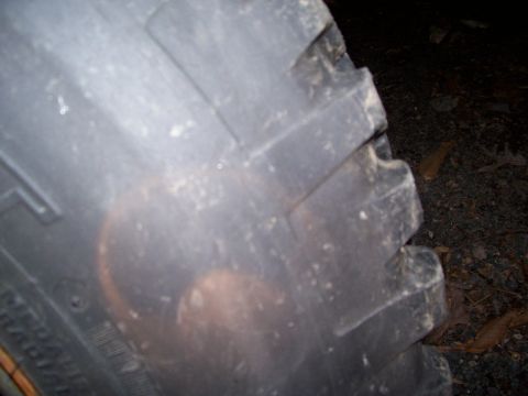 1985 Ford Bronco - A close-up view of a tire tread, showing its aggressive pattern and some sidewall text.