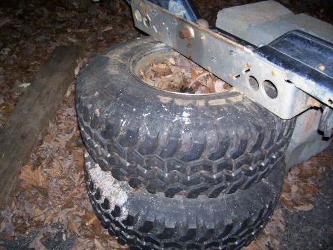 1985 Ford Bronco - Stack of off-road tires with aggressive tread, likely for a truck or SUV, on the ground.