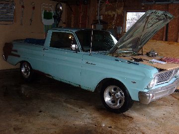 1972 Ford Ranchero - A light blue 1960 Ford Ranchero pickup truck is parked inside a garage with its hood open.