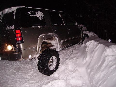2000 Chevrolet Tahoe - This SUV is stuck in a deep snowdrift, with its tires partially buried.