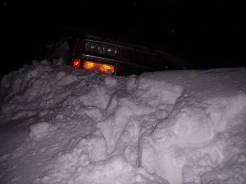 2000 Chevrolet Tahoe - A 2000 Chevrolet Tahoe is buried in snow, with only its front end and headlights visible.