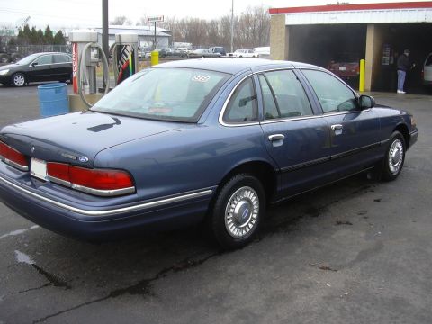 1996 Ford Crown Victoria - A blue 1996 Ford Crown Victoria sedan is seen from the rear 3/4 angle at a car wash.