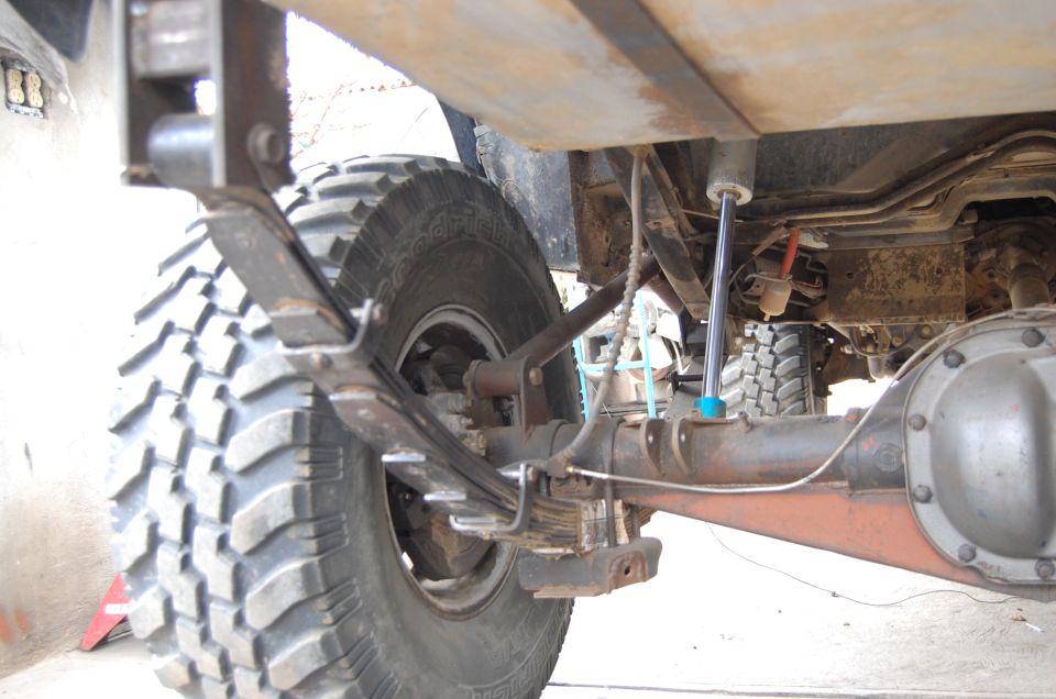 Underside rear of a lifted 4x4 truck showing axle and steering stabilizer