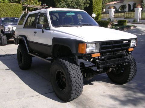 1985 Toyota 4Runner - A modified 1985 Toyota 4Runner is parked in a driveway, with another vehicle visible behind it.