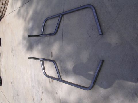 1985 Toyota 4Runner - Two metal roll cage sections are laid out on a concrete surface.