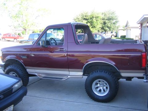 1996 Ford Bronco - This Ford Bronco is parked in a driveway next to another vehicle. The top is off.