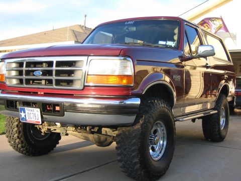 1996 Ford Bronco - This lifted Ford Bronco is parked in front of a house on a sunny day.