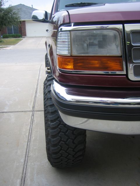 1996 Ford Bronco - Front corner view of a maroon Ford F-Series truck with large tires and chrome accents.