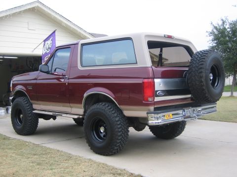 1996 Ford Bronco - Rear view of a lifted 1996 Ford Bronco, oversized tires and a spare tire on the back.